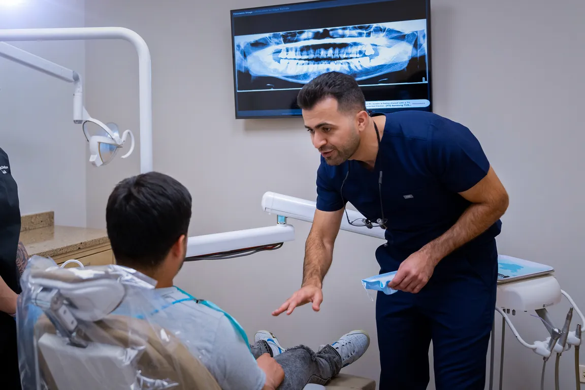 A dentist speaking with a patient in a treatment room in Mount Prospect, IL