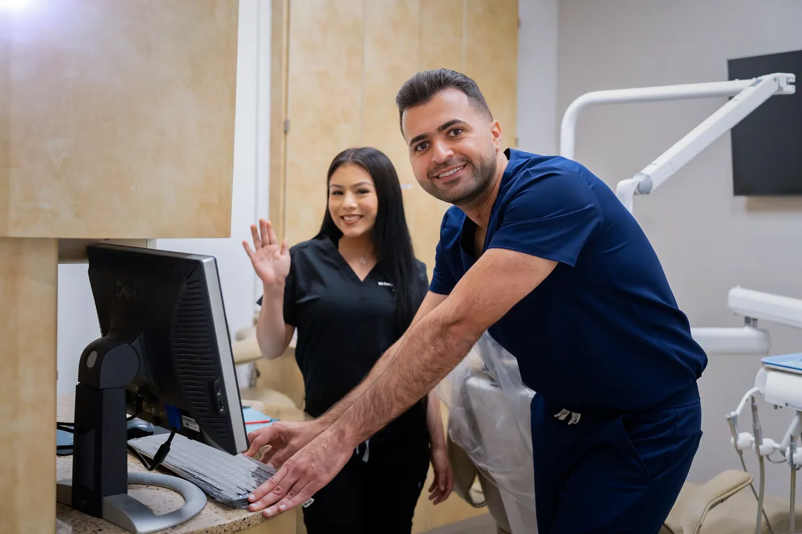 A dentist and team member reviewing patient records in Mount Prospect, IL